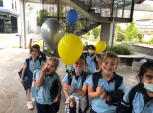 six primary school students with balloons returning to school after COVID lockdown in Melbourne